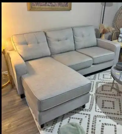 This sectional couch features a chaise lounge and a three-seater sofa, perfect for relaxing or enter...