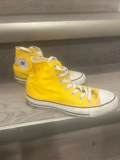 Get ready to brighten up your step with these vibrant yellow Converse high-tops, perfect for adding...