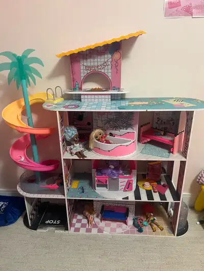 LOL Surprise dollhouse featuring multiple levels, rooms, a waterslide, and a pool area. It's complet...