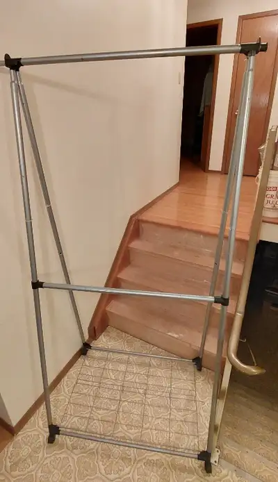 This metal, wheeled, double clothing rack features a grilled platform for also storing shoes, etc. T...