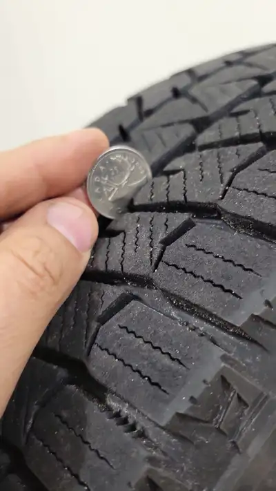 These are a set of four Bridgestone Blizzak WS90 winter tires, size 195/65R15, mounted on steel rims...