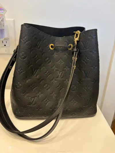 This is a used black Louis Vuitton Neonoe bag in good condition. It's a stylish and versatile bucket...