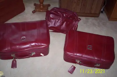 Set of three Samsonite luggage pieces. One large suitcase, one medium, and one carry-on. Red leather...
