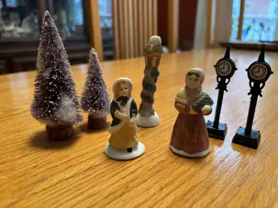Add a touch of nostalgia to your holiday village with this charming set of figurines, lamps, and tre...