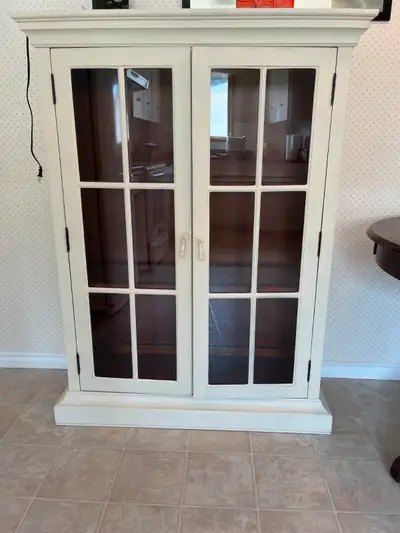 Cabinet with glass doors. Cherry Wood. Purchased from Mcelherans. Inside light.