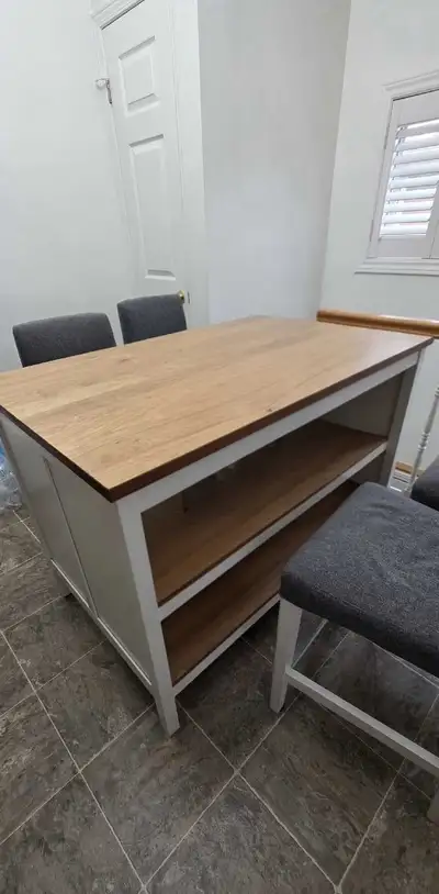 This lovely kitchen island comes with 4 bar stool chairs, offering both style and functionality to y...