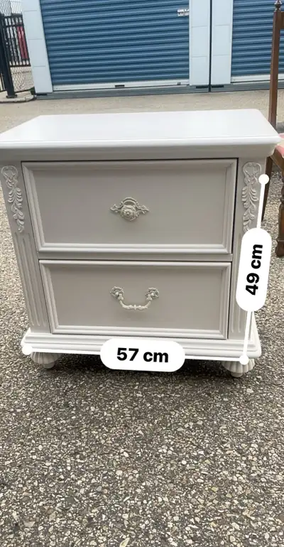 This is a stylish, white nightstand, perfect for adding a touch of elegance to any bedroom. It featu...