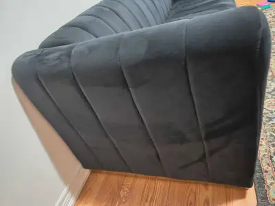 This stylish black velvet sofa brings a touch of modern elegance to any living space. Its sleek desi...