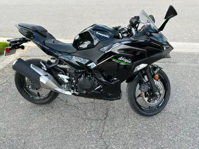 Black Kawasaki Ninja 500 with a custom muffler and installed fender eliminator