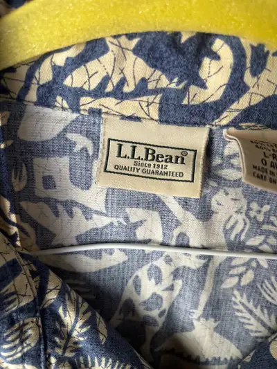 This is a pre-owned L.L.Bean men's short sleeve button-up shirt featuring a blue and beige tropical...