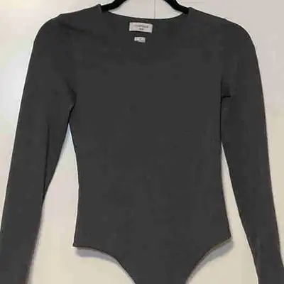 This is a new, Aritzia bodysuit in a size small, featuring a long-sleeve design and a sleek, form-fi...