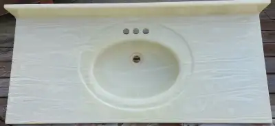 Beige, marble vanity top with built-in oval sink, with backsplash. It is in very good condition, wit...