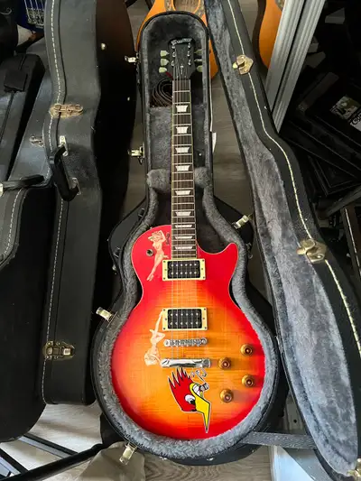 This Epiphone Les Paul Special II features a distinctive sunburst flame top finish with custom pin-u...