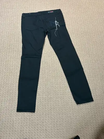 These are Bongo brand black jeans in a size 9 with a skinny leg fit, featuring a ripped design at th...
