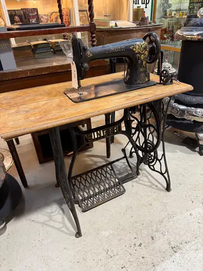 Nice old industrial singer sewing machine. Wood top is worn/warped. Machine appears to be in good wo...