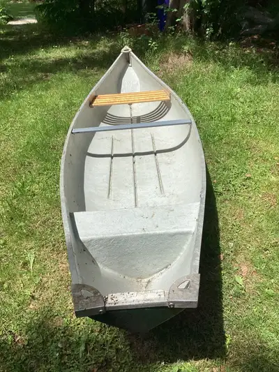 Large canoe with two-stroke small Evinrude outboard motor and paddles. Seats three comfortably