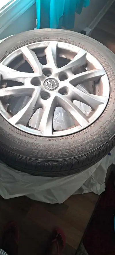 I'm selling a set of (4) used Mazda wheels with summer Bridgestone tires (205/60/16). The tires stil...