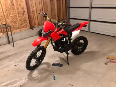 This is a used red dirtbike, perfect for off-road adventures with its robust design. It's ready to t...