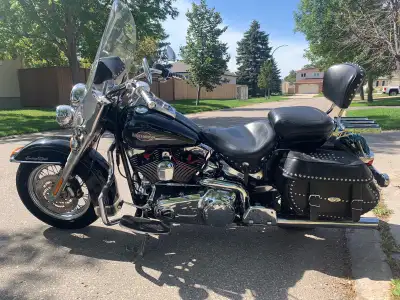 This barely ridden “ MINT”Heritage Softail Classic sports a black finish, windshield, studded leathe...