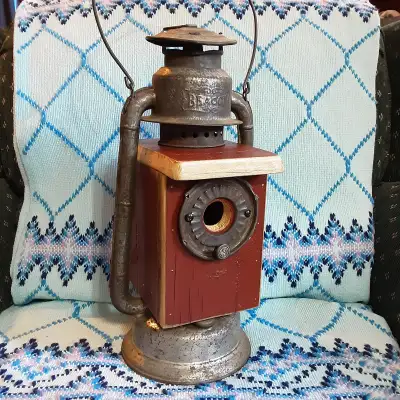 A 100 year old barn lantern repurposed into a decorative and useful birdhouse. Old farm fence boards...