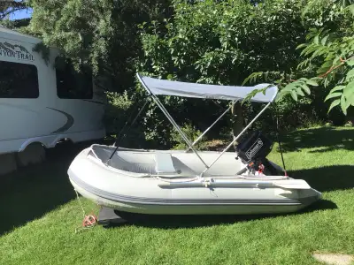 10ft inflatable with canopy inter locking hard floor,seat ,oars pump cover and a Coleman 5hp motor w...