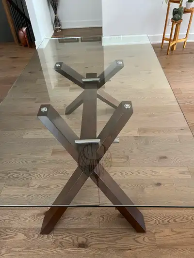 Beautiful glass top dining table with x style solid wood base In great condition. Measures 72 inches...