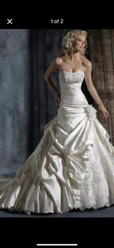 This stunning wedding dress features a strapless design with intricate beading on the bodice and a b...