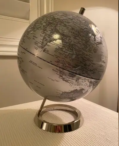 This is a globe with a metal stand. It displays countries and oceans. It's a good size for a desk or...
