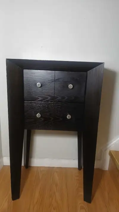 This sleek, black end table is a stylish and functional addition to any room, featuring a compact de...