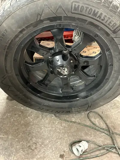 I am selling a single Motomaster Cooper Tire winter tire, sized at 35x12.5R17, mounted on a black Tr...