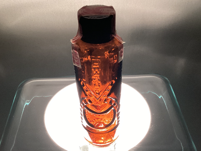 Embossed with HAWAII AND TEKE MASK this amber bottle is in excellent condition with no chips. Has or...