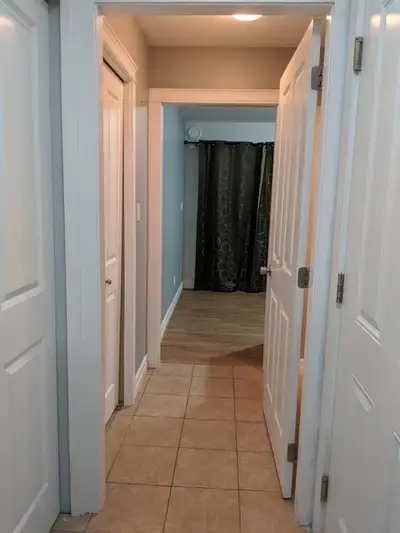 Cozy bachelor suite available for rent, featuring a functional kitchenette with a sink, cabinets, an...