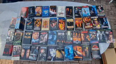 Collection of VHS movies, featuring classics like "Titanic," "Jurassic Park," and "Men in Black," Te...