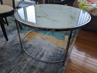 Modern round glass coffee table with chrome legs. Light and easy to move. It is in very good conditi...