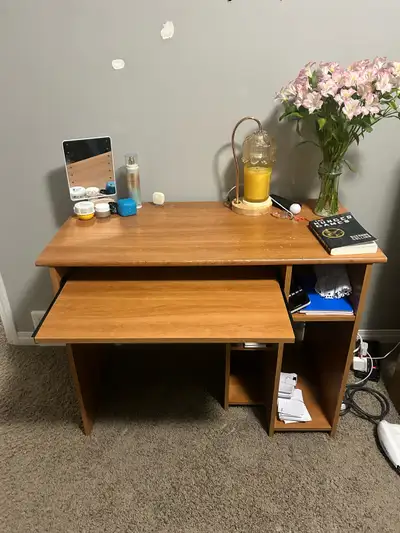 This is a used desk with a sliding keyboard tray and a side storage compartment, perfect for a stude...