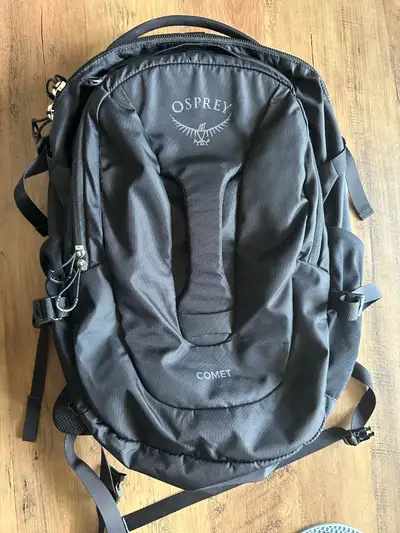 This is an Osprey Comet Backpack, perfect for travel or daily use with a 30L capacity. It's black an...