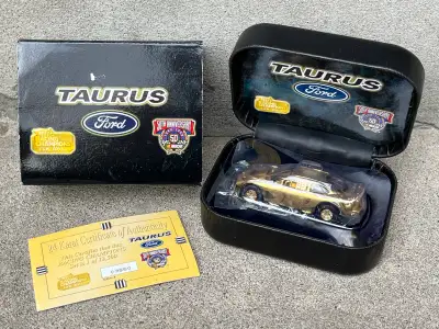 1998 Racing Champions 24K Gold Ford Taurus diecast model car, released to commemorate NASCAR's 50th...