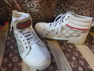 These Gucci high-top sneakers feature the iconic GG monogram canvas with signature red and green web...