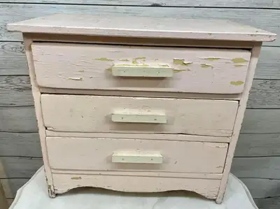 Jolie petite commode jouet ancienne. Elle est en bois. Fait à la main. De couleur rose pâle. Même le...