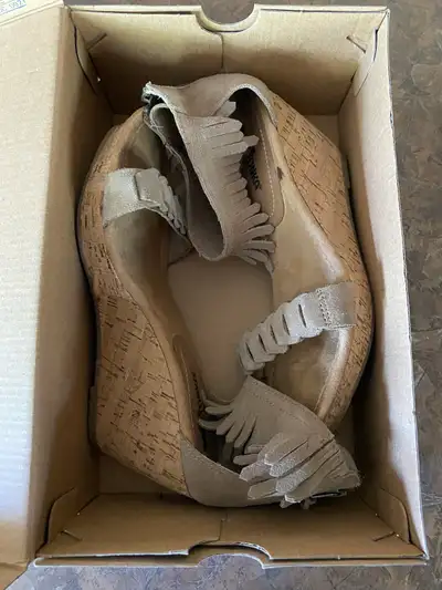 Step out in style with these used Minnetonka wedge sandals, size 8 EU 38, featuring chic fringe deta...