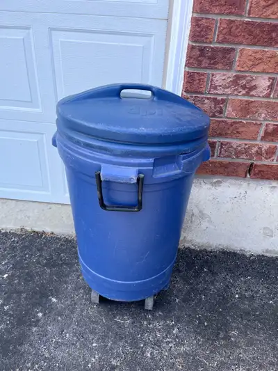 Medium Blue Garbage Can Used For Storage. Used for outdoor toys, tennis rackets etc. is dented on to...