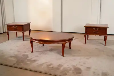 Beautiful vintage wood living room table set featuring a round coffee table and matching pair of end...