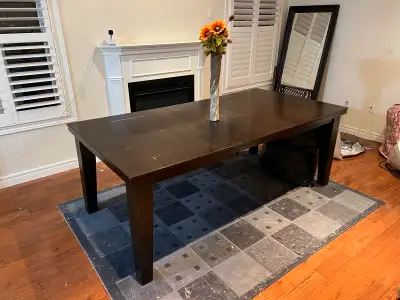 This elegant dining table is perfect for family dinners or entertaining guests, featuring a rich, da...