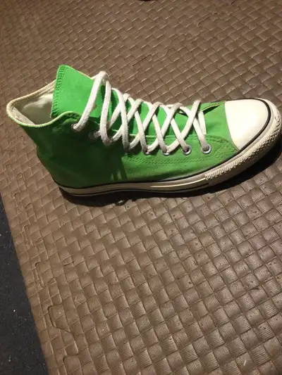 Get ready to turn heads with these vibrant green Converse All-Star high-top sneakers, a bold stateme...