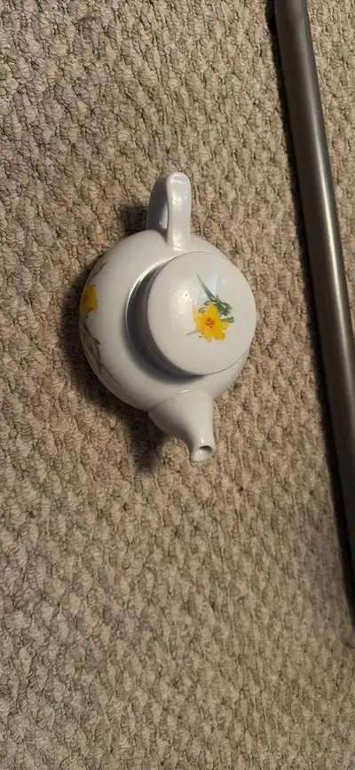 This charming, pre-owned floral porcelain teapot features delicate hand-painted yellow blossoms, mak...