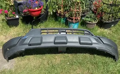 Front Bumper Cover from a 2018 Nissan Pathfinder. Slight damage (scuff & crack) as shown. New OEM is...