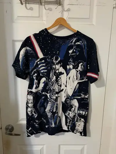 This pre-owned Mad Engine Star Wars graphic t-shirt features iconic character artwork on the front a...