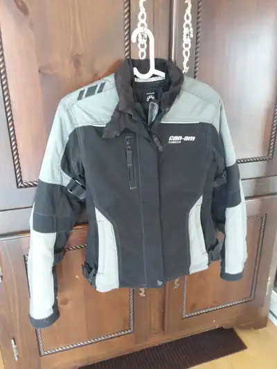 Description : Manteau de moto noir et gris de marque Can-am avec doublure amovible, à l'état neuf. N...