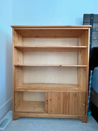 This is a bookshelf that is perfect for any room. It features adjustable shelves and a cabinet at th...