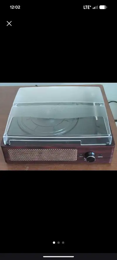 This is a vintage-style record player with built-in speakers. It has a headphone jack and a power/vo...